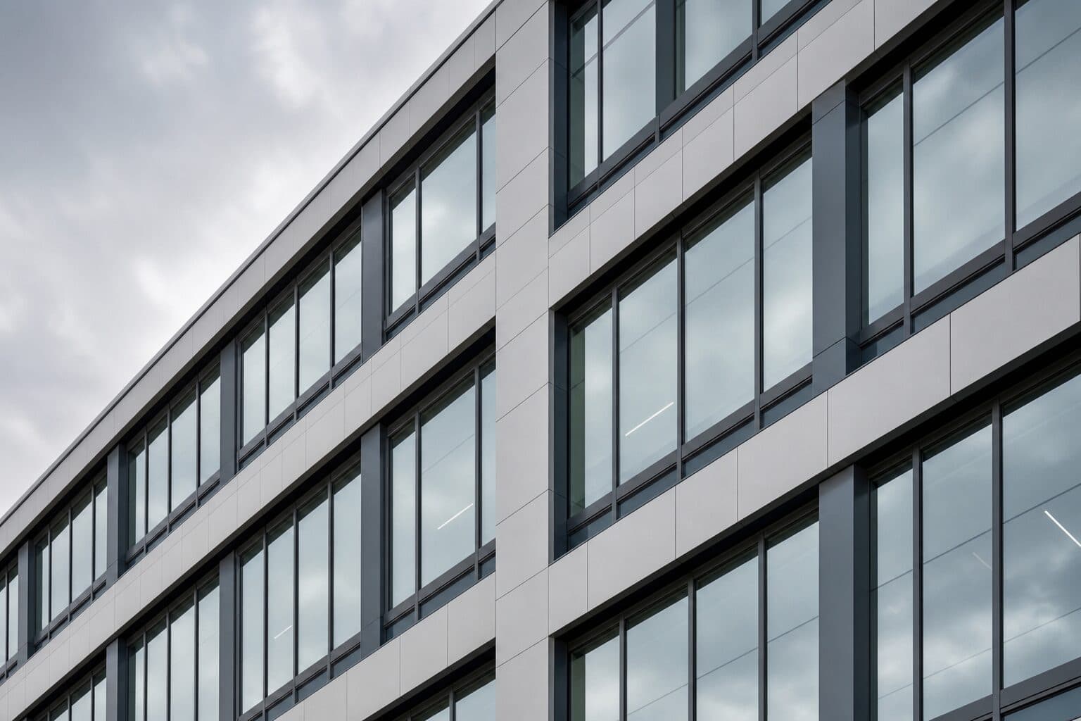 Contemporary office building facade glazed with large windows in dark frames